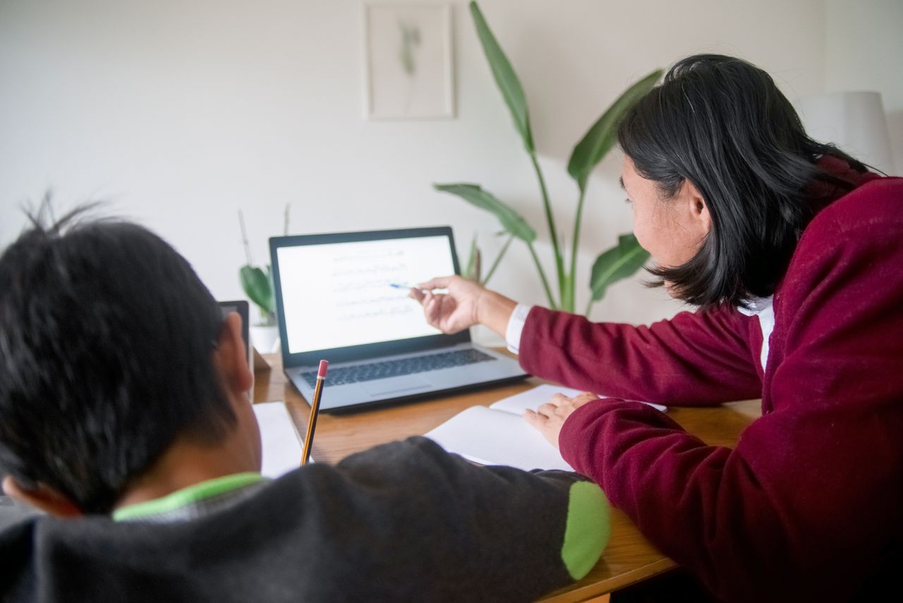 Mastering the First Impression: Your intriguing post title goes here Adult guiding child in learning session using a laptop at home. Ideal for education themes.
